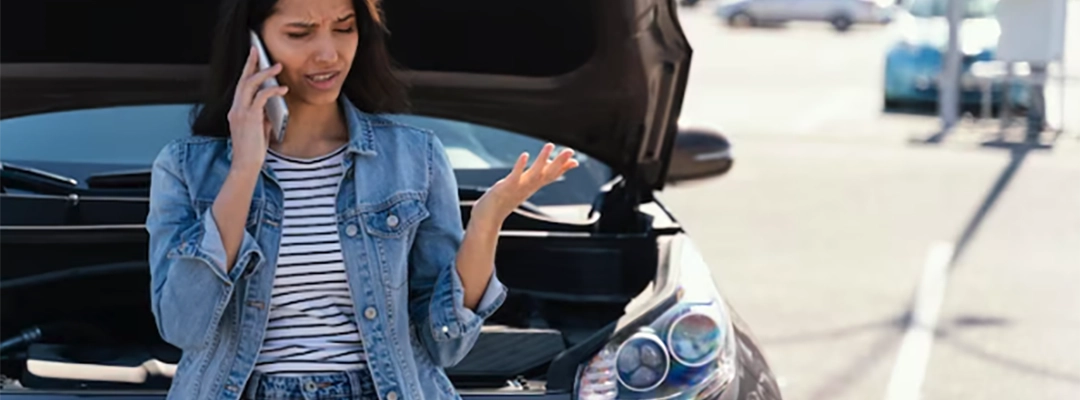 Evitar estafas al comprar-mujer frente a carro averiado