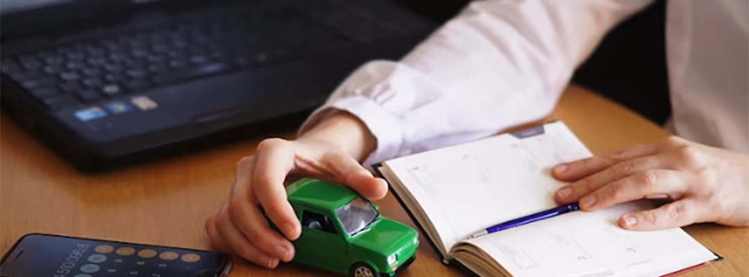 Mano con un carro y dinero sobre la mesa - ofertas de crédito de vehículo