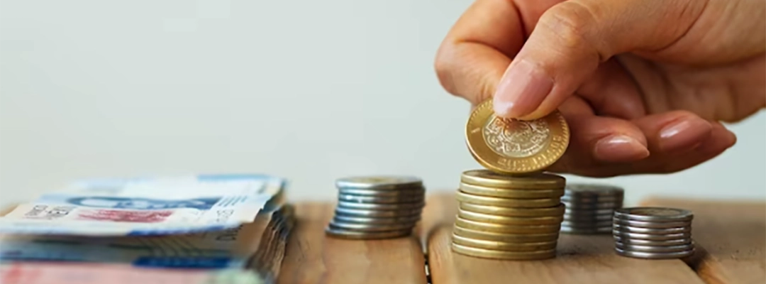 Mano con moneda y dinero en la mesa-zalabin