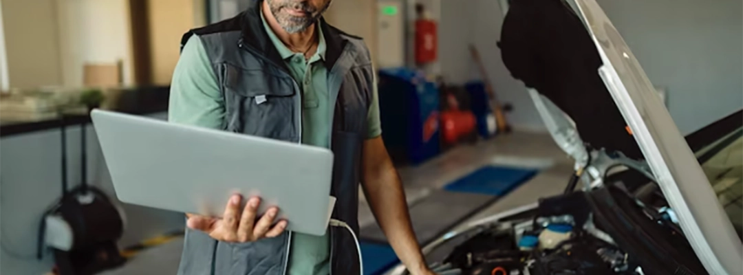 3-Hombre revisando su carro con computador en la mano