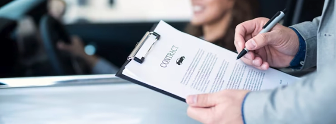 Persona con documentos en la mano y mujer en el carro